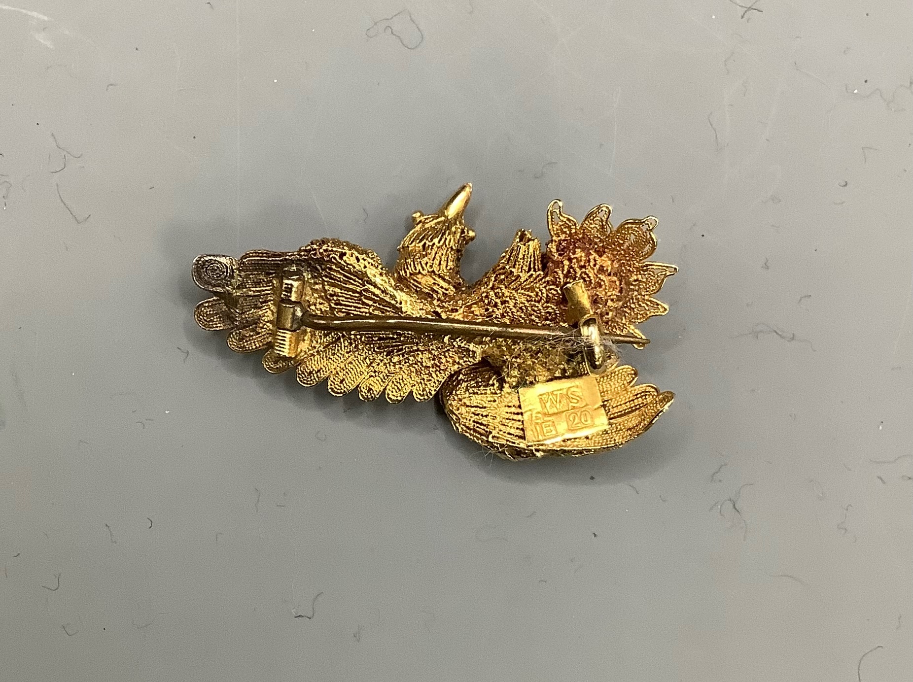 A Chinese filigree yellow metal eagle brooch, stamped 'WS 20 (with character marks)', 36mm, gross 6.5 grams.